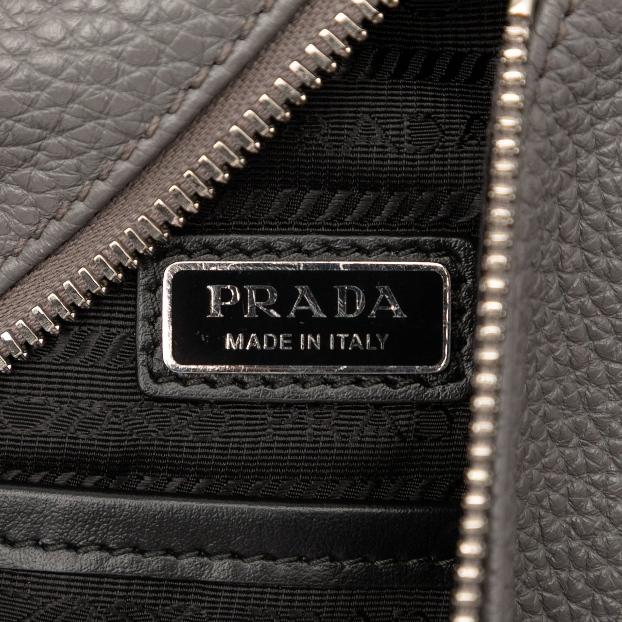 Prada Vitello Daino Logo Embossed Sling Bag Grijs